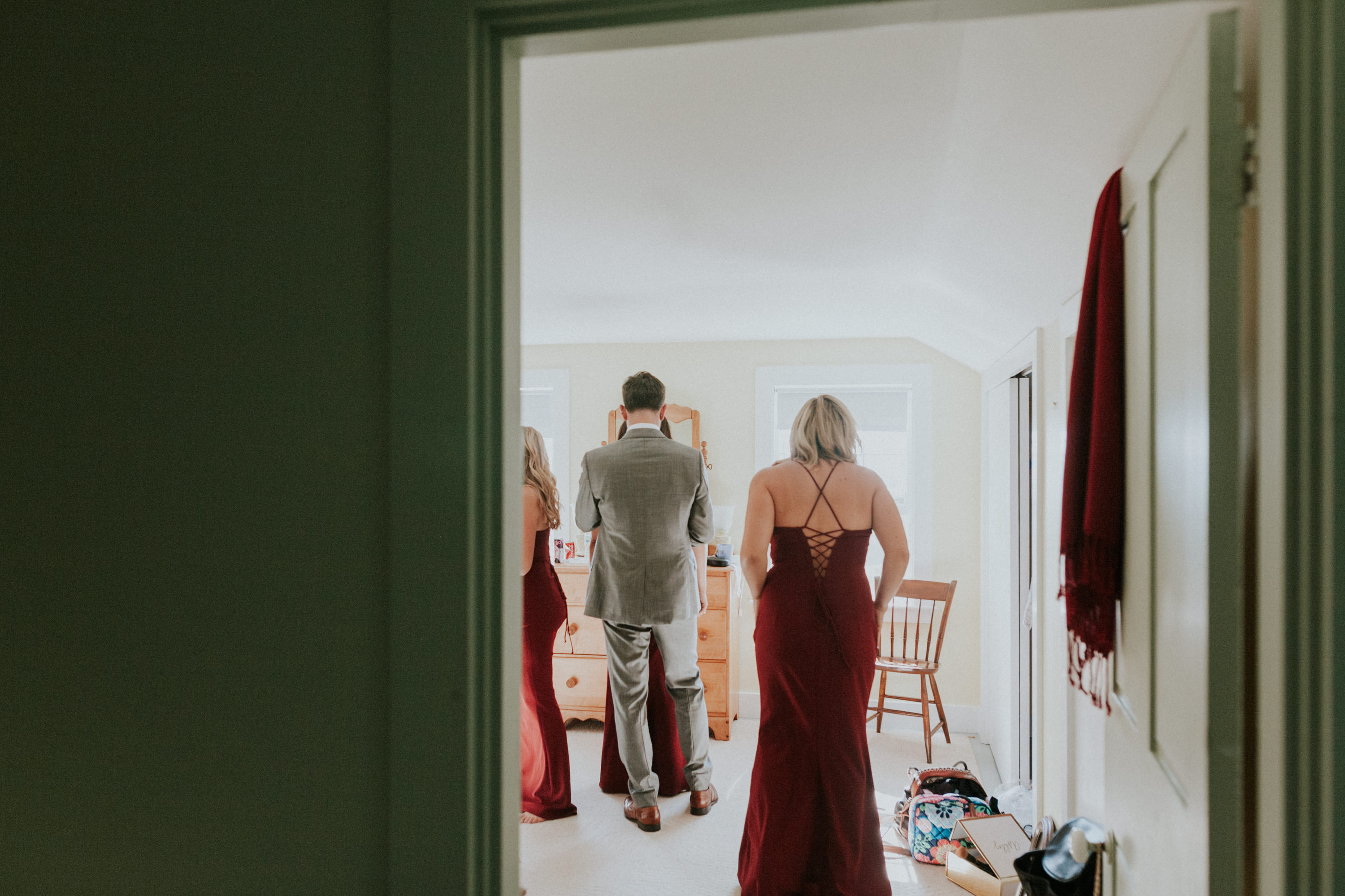 bridesmaid putting on dress, bridesmaids helping eachother