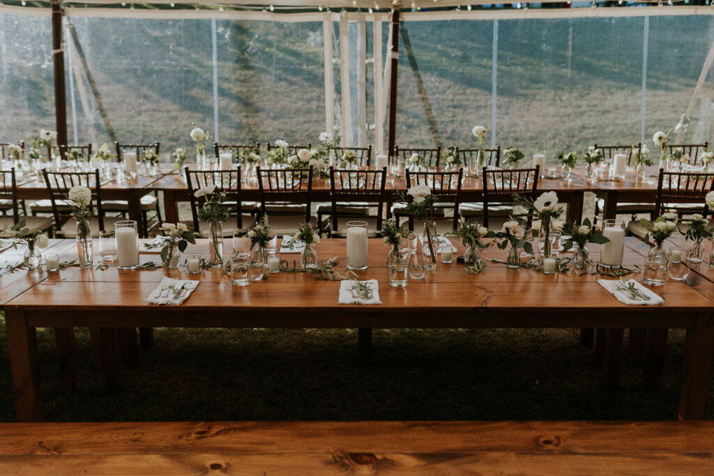 long tables decorated with individual white flower varieties in small vases at a Cape Cod wedding reception