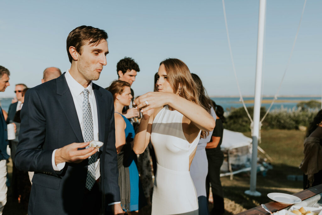 bride and groom eat oysters on the half shell after their Cape Cod wedding ceremony
