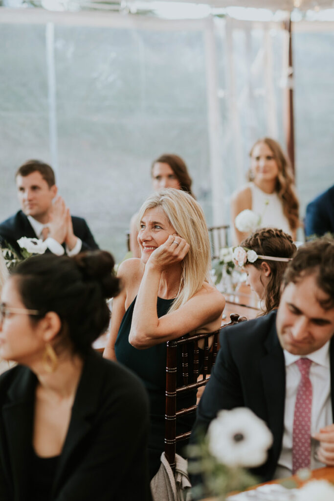 beautiful mature blonde woman watches speeches at Cape Cod wedding reception