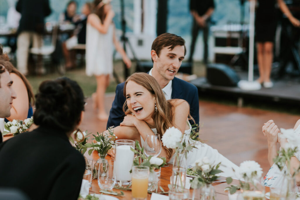 bride laughs at head table with Groom at their Cape Cod reception