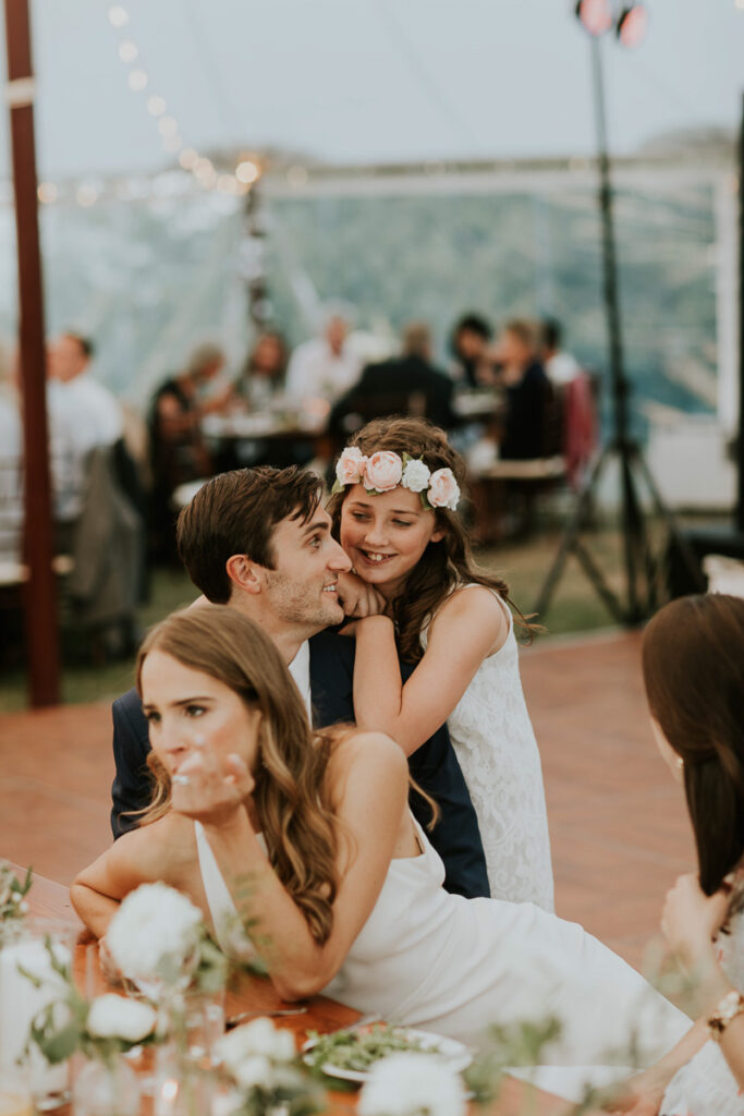 flower girl hugs groom at Cape Cod wedding reception