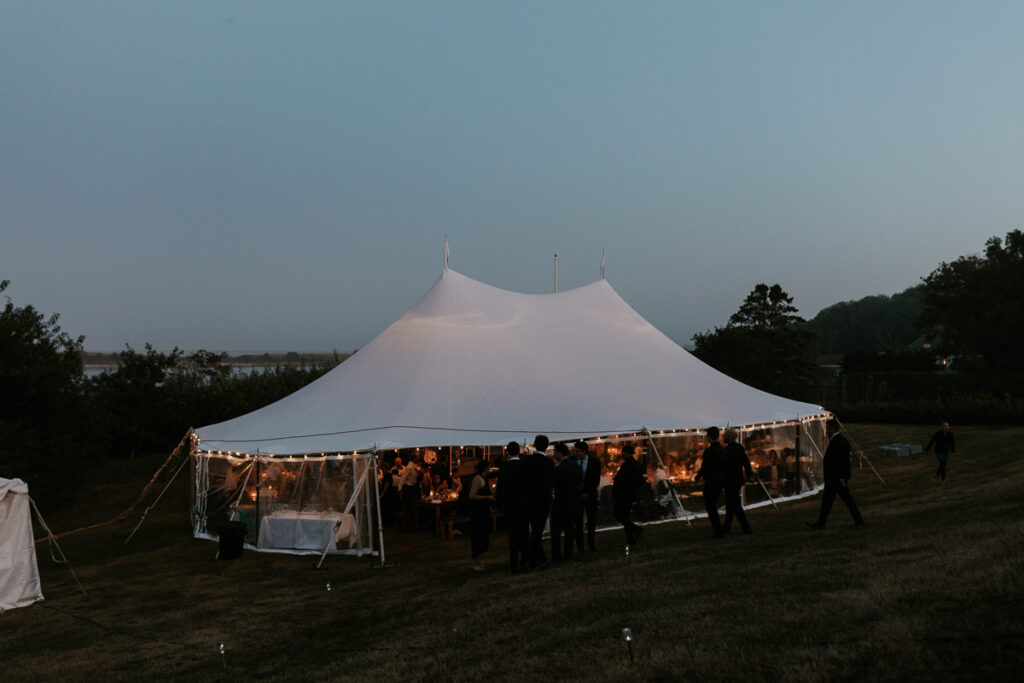Cape Cod wedding reception held in a large white tent in the twilight