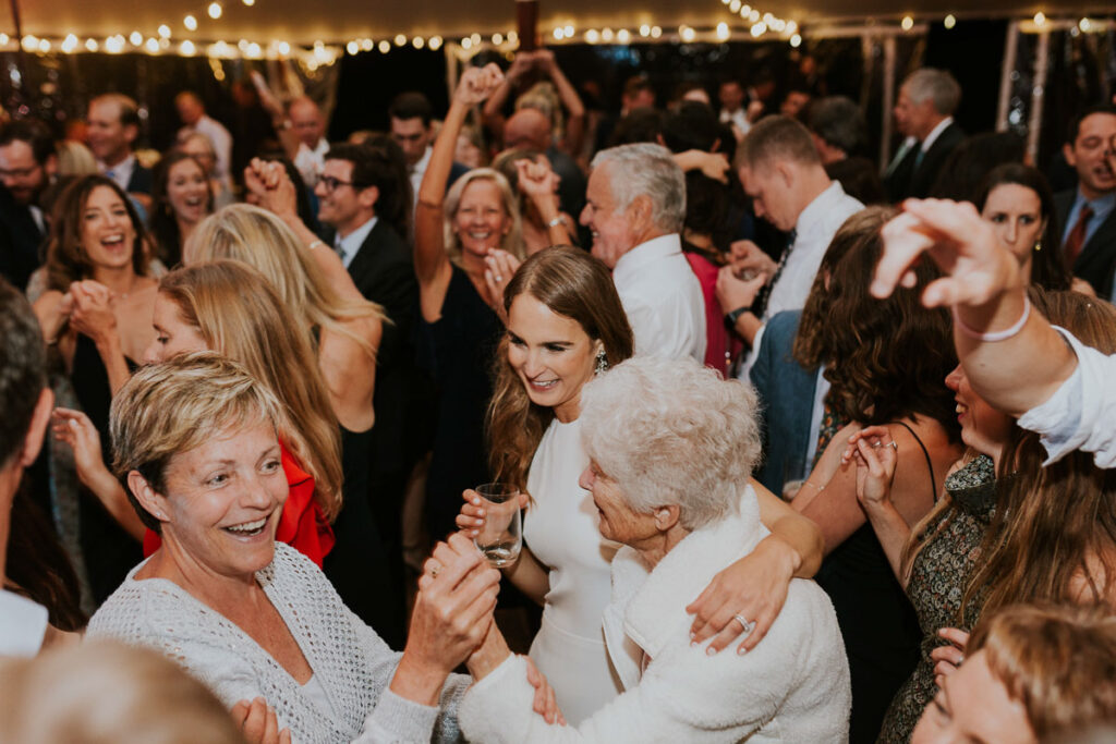 Cape Cod wedding reception guests dance while smiling and enjoying themselves