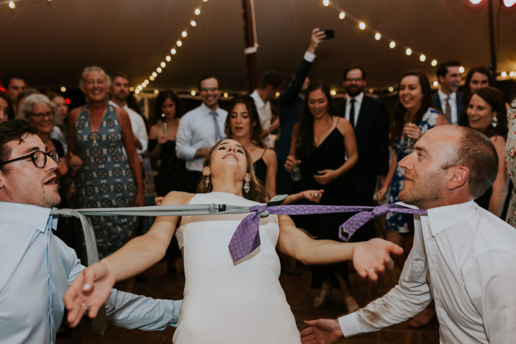 bride does the limbo under guests ties that have been tied together