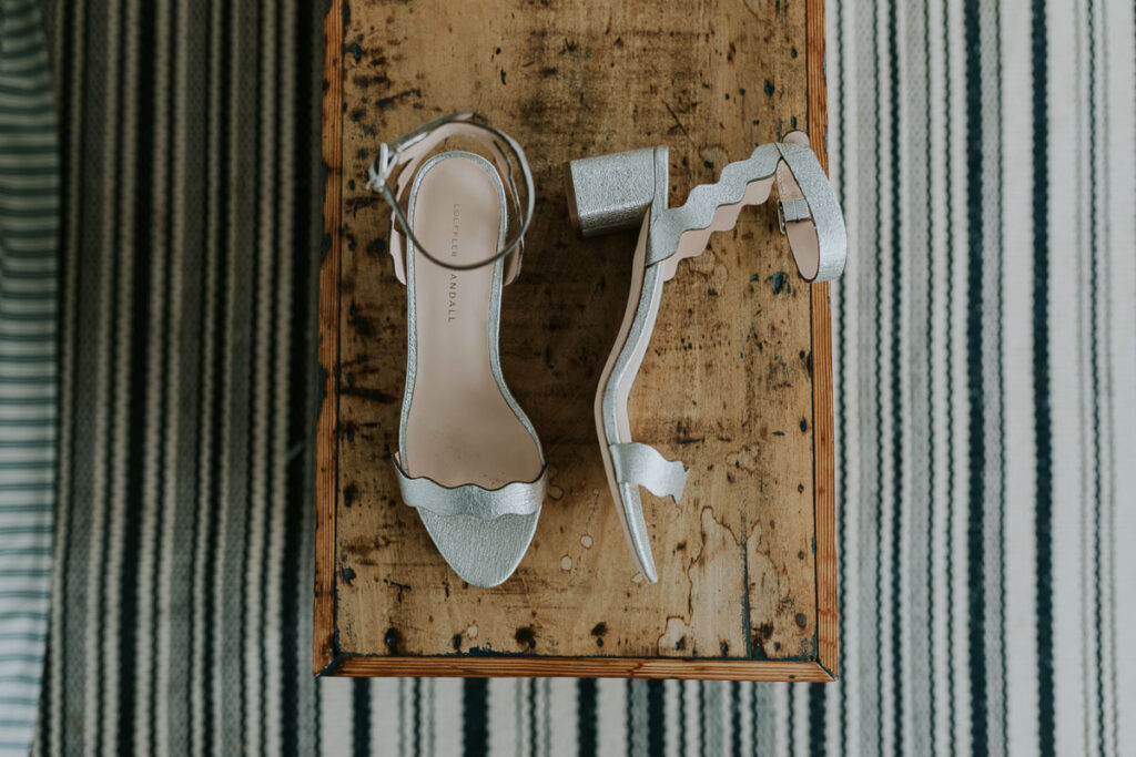 Silver Loeffler Randall wedding shoes laying on a bench