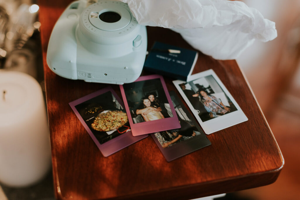 fun polaroids of bride and her friends sit on a wooden table on the morning of her wedding