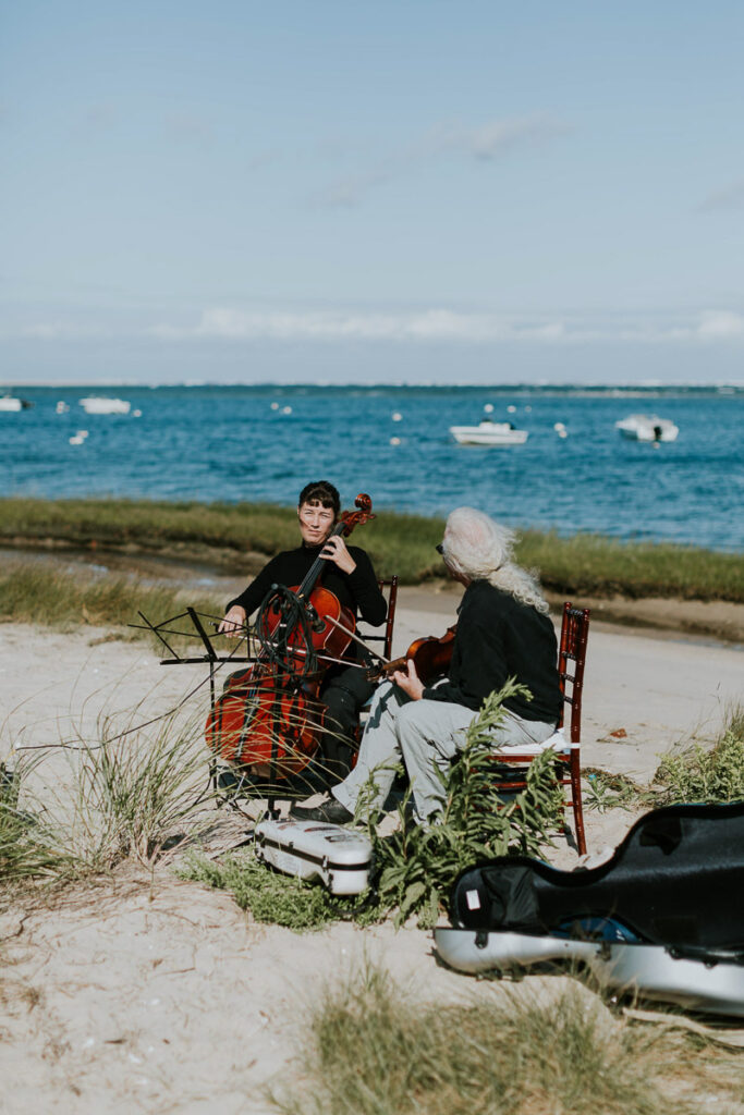Cello and violin players on the beach in Cape cod during outdoor wedding ceremony