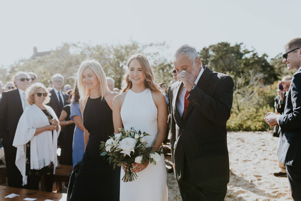 Father wipes his eyes as he walks his daughter down the aisle at Cape Cod wedding
