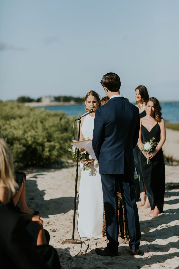 bride reads vows to groom on the beach in Cape Cod