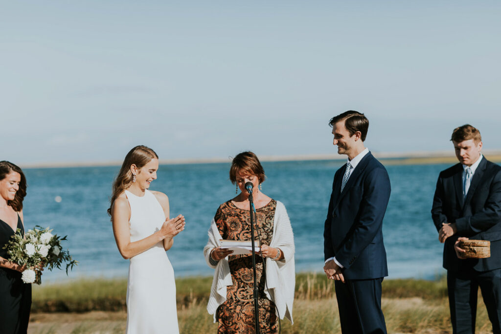 wedding party laughs during marriage ceremony on the beach in Cape Cod